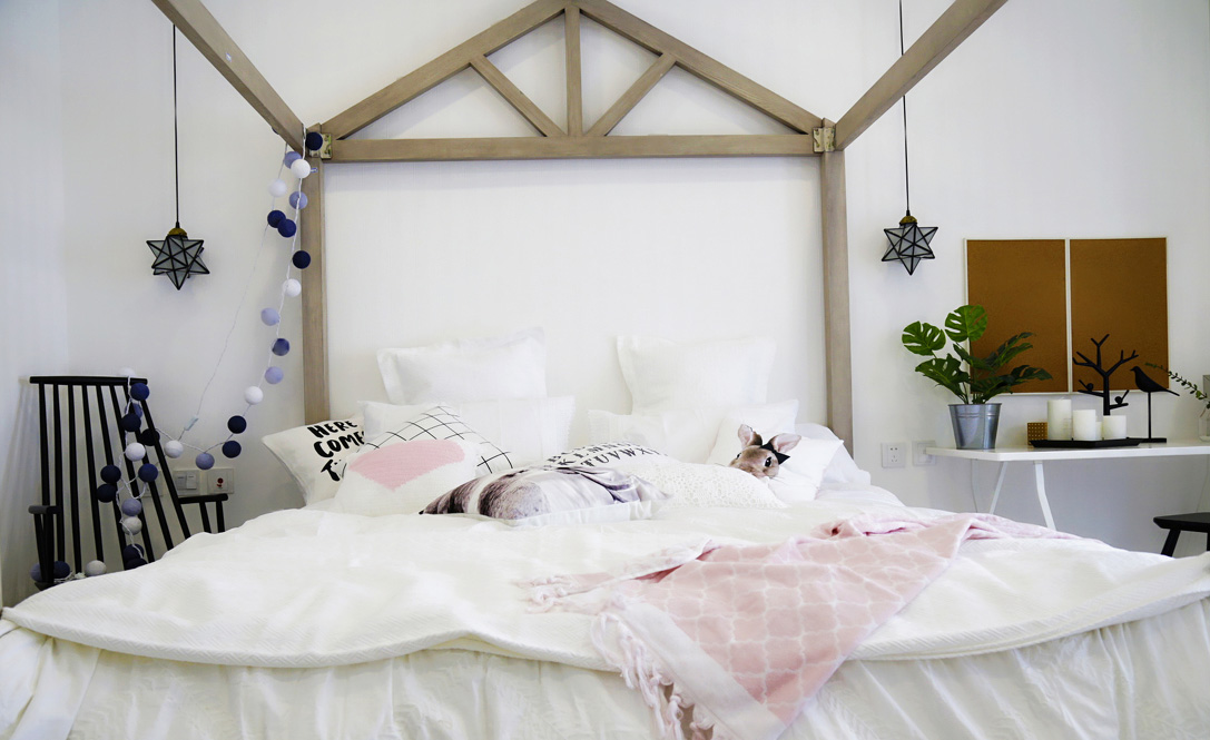 围绕着森林主题，用白色的软和来让卧室变得更有梦幻感。木质框架还能挂上纱帘，往实用方向上说是放蚊虫，往情感方向上说则是浪漫风格的延续。